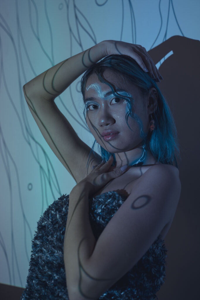 Artistic phot of a model with a streak of blue makeup and a fashionable dress to personify the idea of fluidity