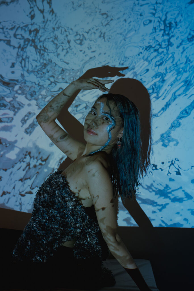 Artistic phot of a model with a streak of blue makeup and a fashionable dress to personify the idea of fluidity