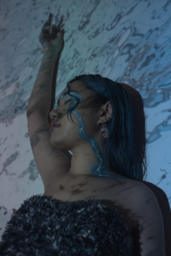 Artistic phot of a model with a streak of blue makeup and a fashionable dress to personify the idea of fluidity